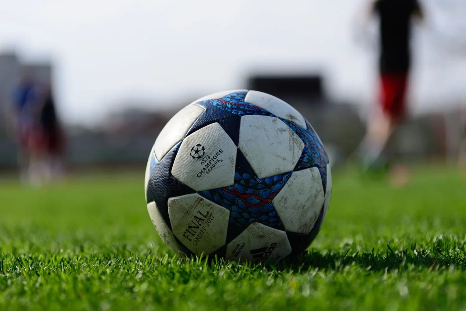 UEFA Champions League Fußball auf Rasen vor unscharfen Spielern im Hintergrund