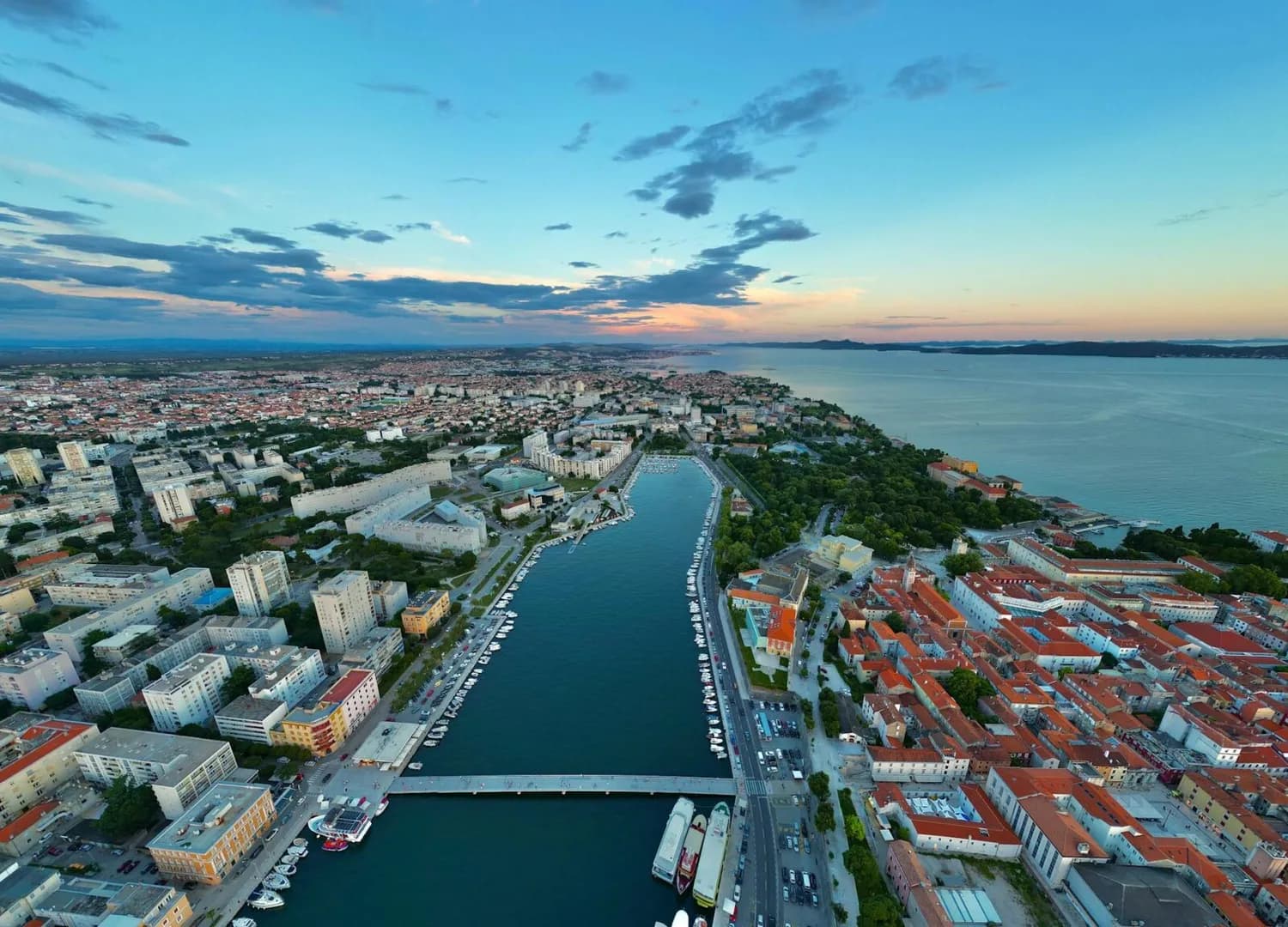 Luftaufnahme von Zadar Kroatien mit Kanal, Uferpromenade, Booten und rotdachigen Altstadthäusern bei Abendlicht