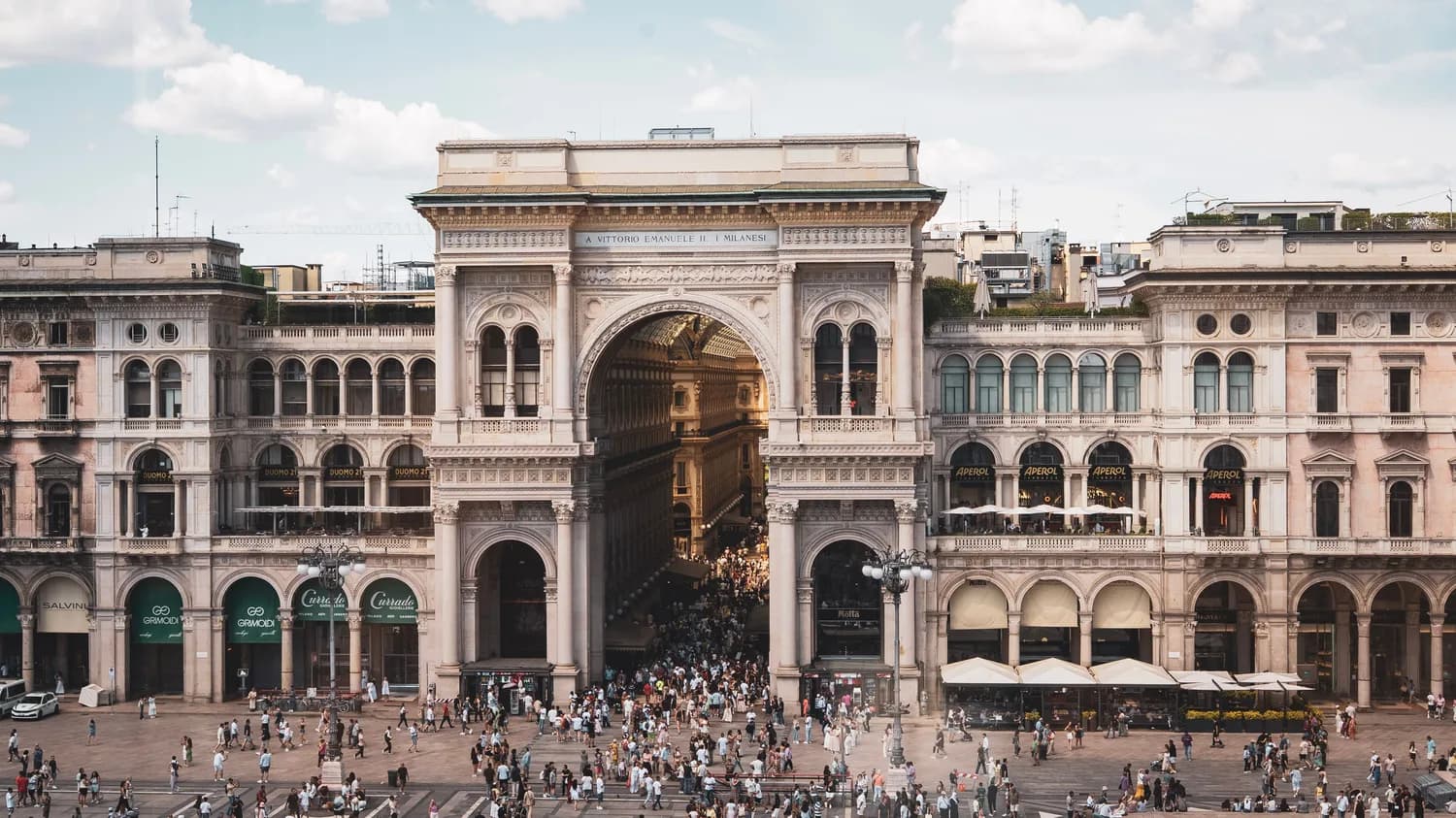 Galleria Vittorio Emanuele II in Mailand mit prunkvoller Arkadenfassade und Menschenmenge auf der Piazza, Lifestyle-Szene und Einkaufspassage