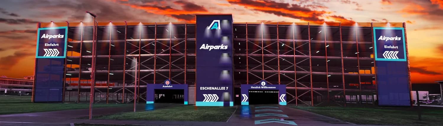 Airparks mehrstöckiges Parkhaus München bei Sonnenuntergang mit beschilderter Einfahrt, Ausfahrt und blauen Wegweisern am Gebäude Eschenallee 7