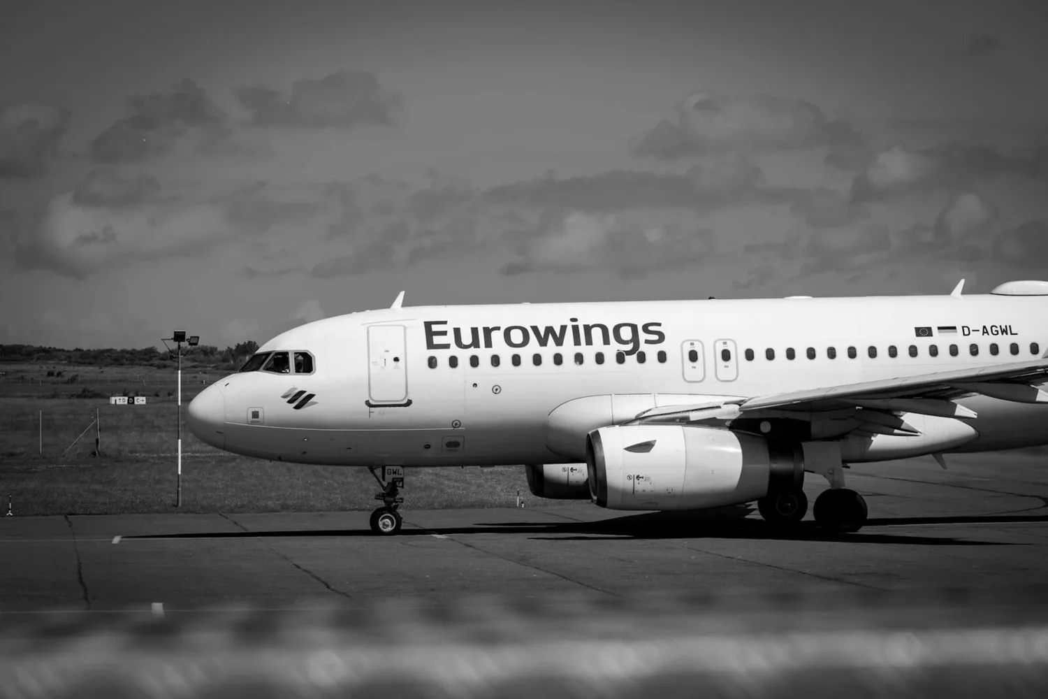 Eurowings-Passagiermaschine am Rollfeld mit sichtbar großem Schriftzug auf Rumpf und geparktem Triebwerk