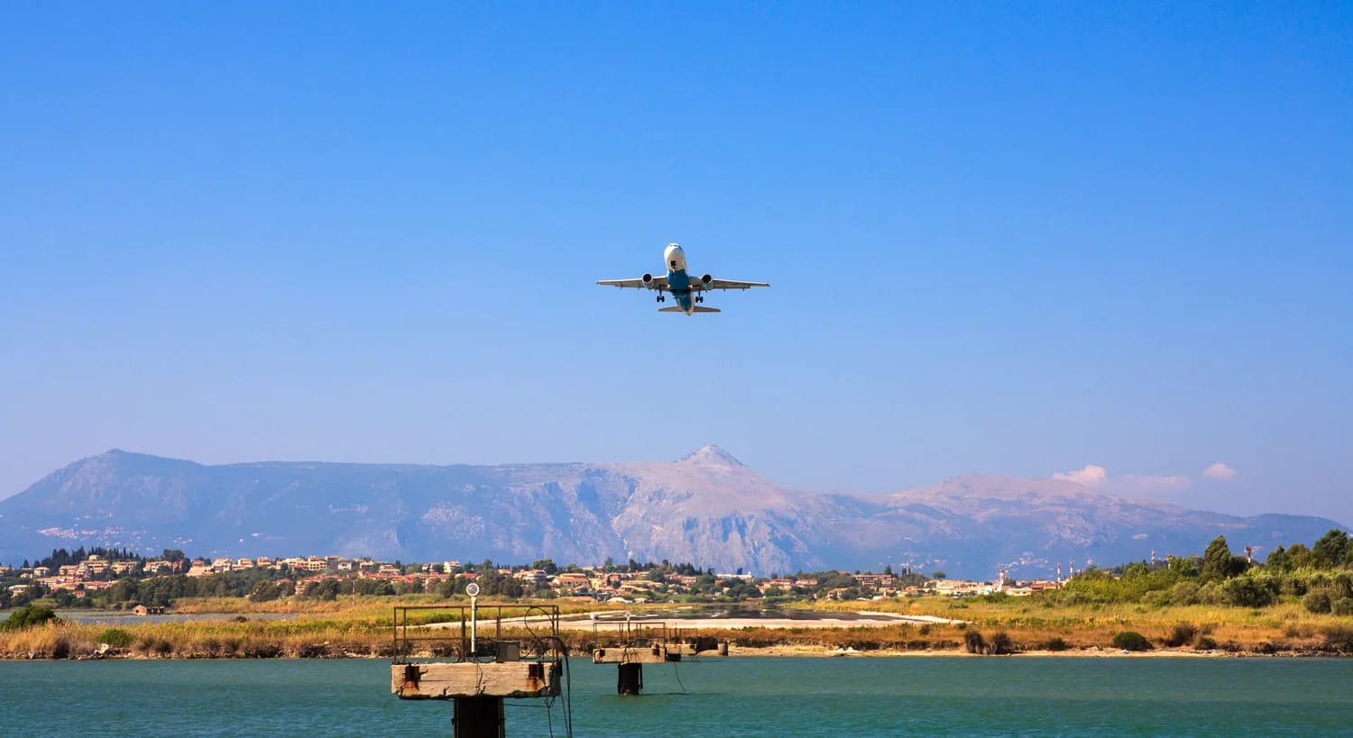 Flugzeug über der grünen Berglandschaft von Korfu im Ionischen Meer