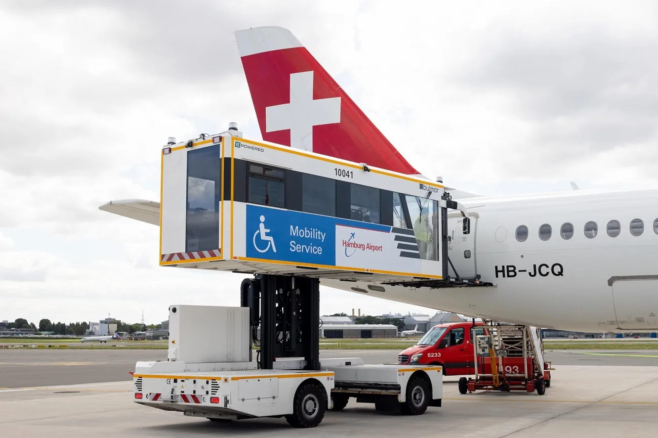 Mobiler Boarding-Highloader mit Mobility Service Beschilderung hebt Passagierplattform an Flugzeugtür einer Swiss-Maschine (HB-JCQ) am Flughafen Hamburg