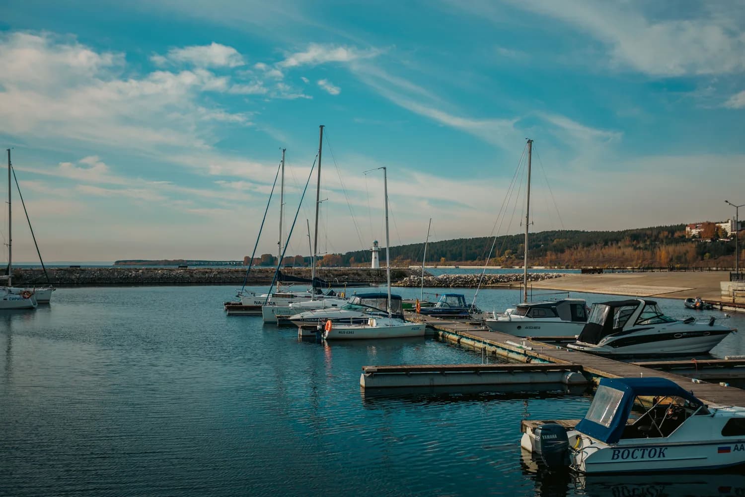 Jachthafen in Warna, Bulgarien mit vertäuten Segel- und Motorbooten, Stegen und Leuchtturm im Hintergrund