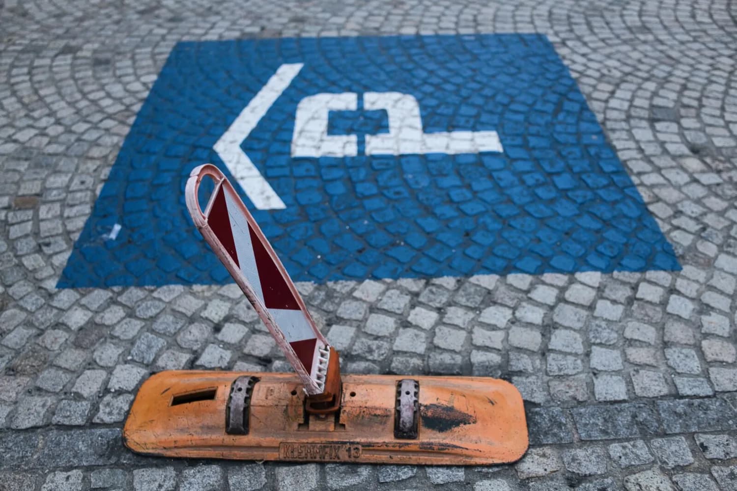 Parkblocker und Markierung für kostenloses Parken am Flughafen Memmingen auf gepflastertem Parkplatz