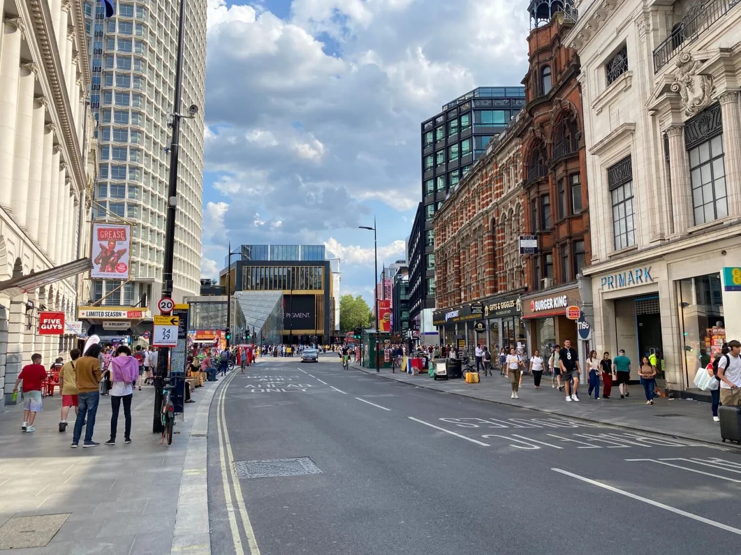 Oxford Street in London mit Passanten, Geschäften wie Primark und Burger King, historische und moderne Fassaden entlang der Einkaufsstraße beim Tageslicht