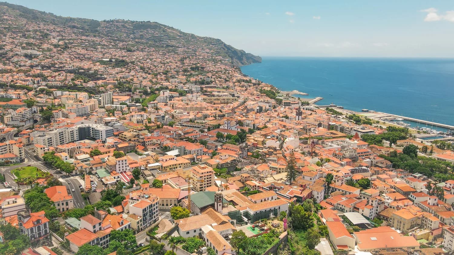 Luftaufnahme der Küstenstadt Funchal auf Madeira mit Bucht, Altstadt und Bergkulisse