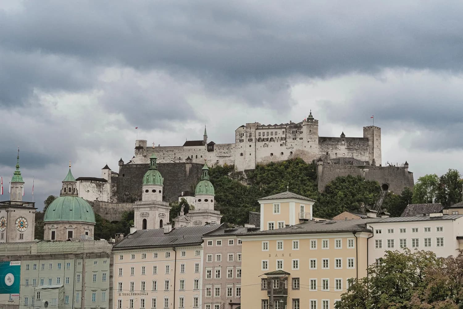 Hohensalzburg-Festung auf dem Festungsberg über der Altstadt von Salzburg mit kirchlichen Kuppeln und historischer Stadtsilhouette bei bewölktem Himmel