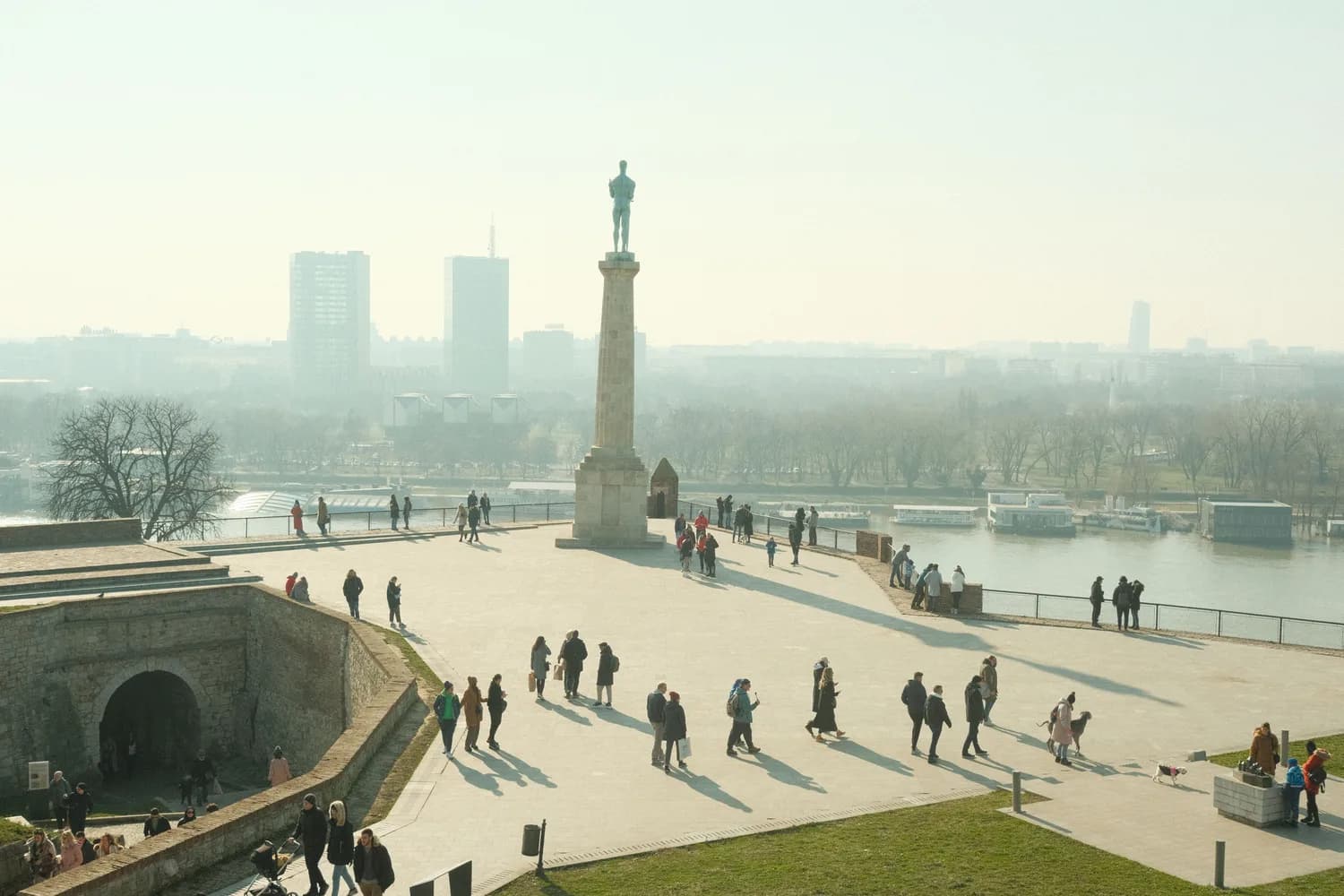 Panorama von Kalemegdan-Festung in Belgrad mit Denkmal auf Säule, Besucher am Aussichtspunkt und Blick auf Donauufer und Stadtufer von Belgrad