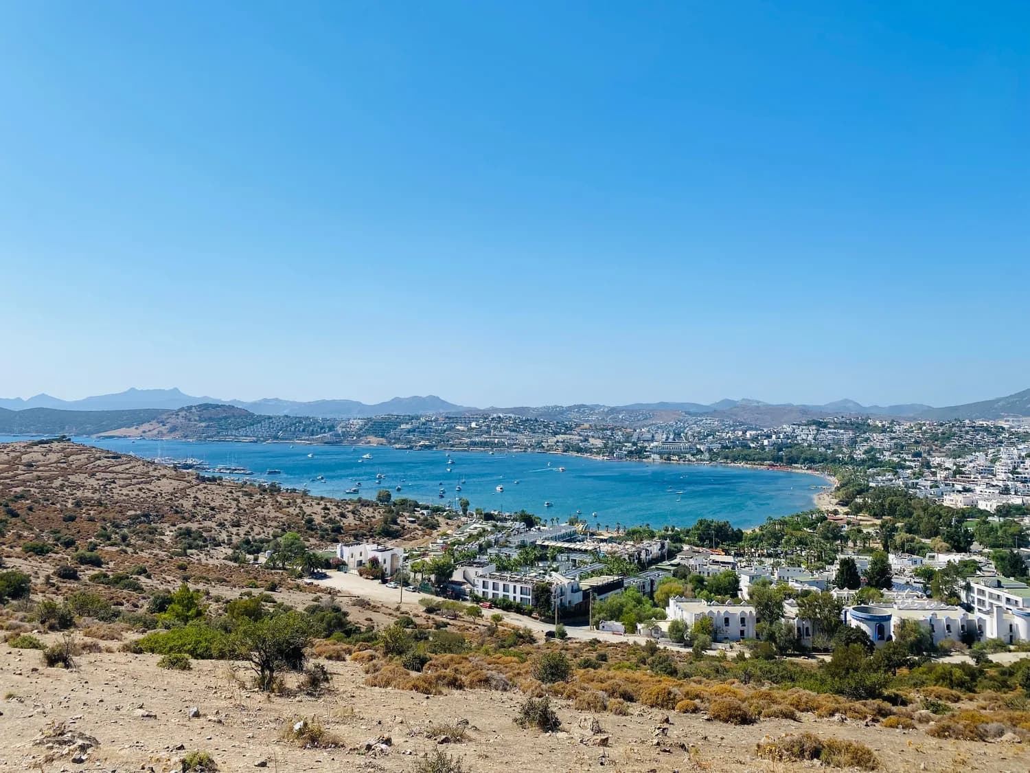 Bodrum Küstenstadt mit Hafen und blauem Ägäis-Meer, Yachten in der Bucht, weiße Bauten und hügelige Landschaft