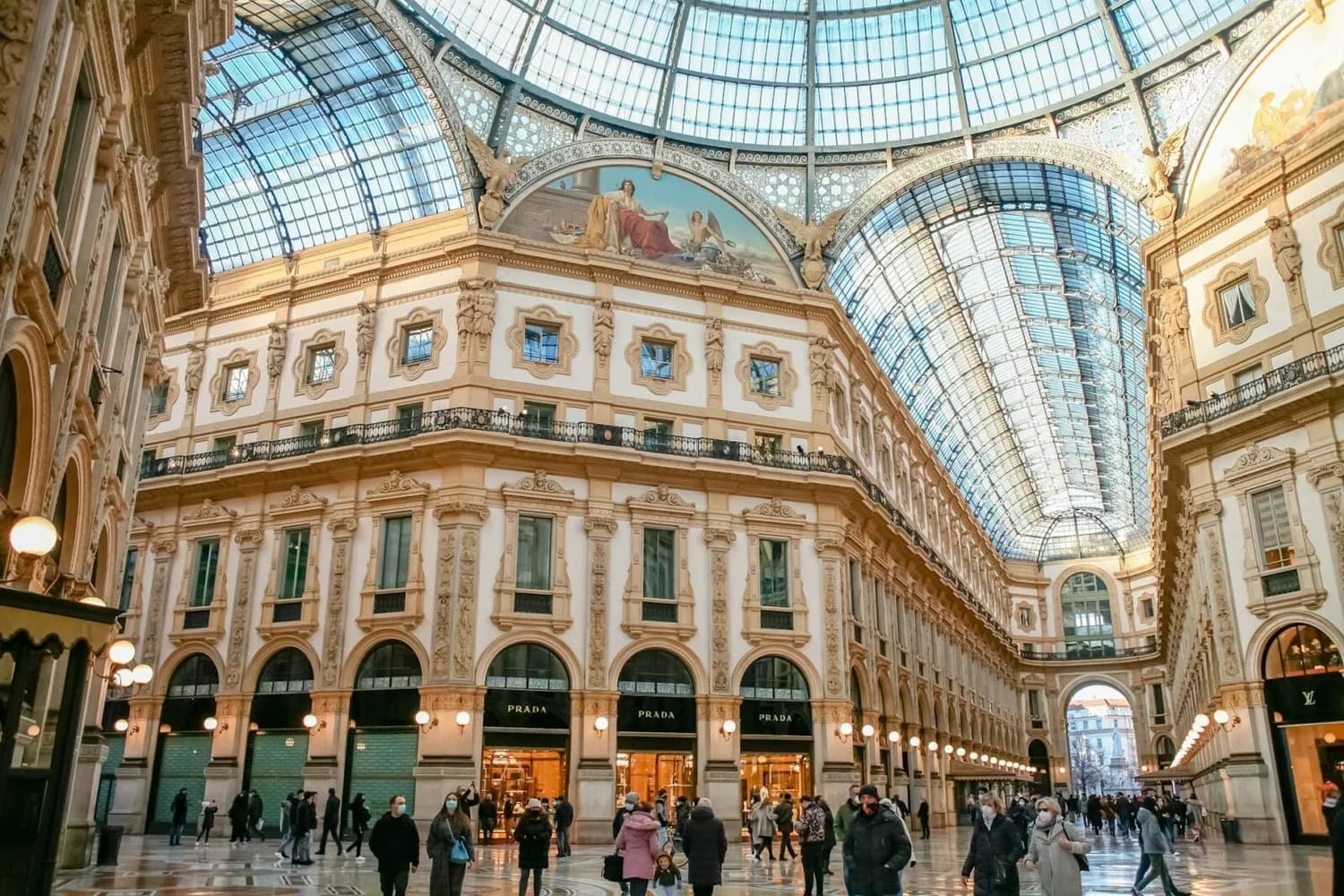 Galleria Vittorio Emanuele II Mailand Panorama der prachtvollen Einkaufsgalerie mit Glasdach, historischen Fassaden und Luxusgeschäften wie Prada, Fußgänger im Innenraum in der Lombardei