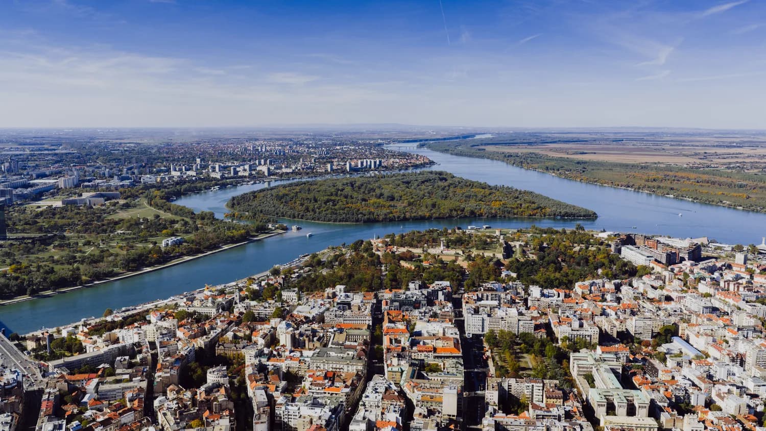 Luftaufnahme von Belgrad mit Donau, Flussbogen, Ada Ciganlija Insel und städtischem Panorama Serbiens