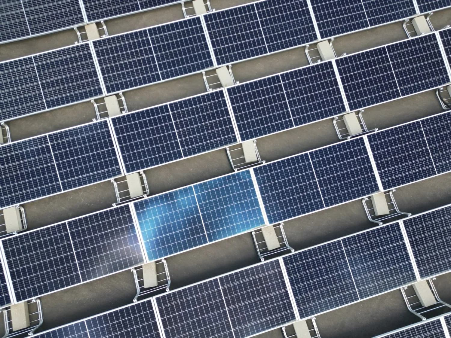 Dach mit Reihen von Solarzellen auf Montageschienen, Nahaufnahme paralleler Photovoltaik-Module