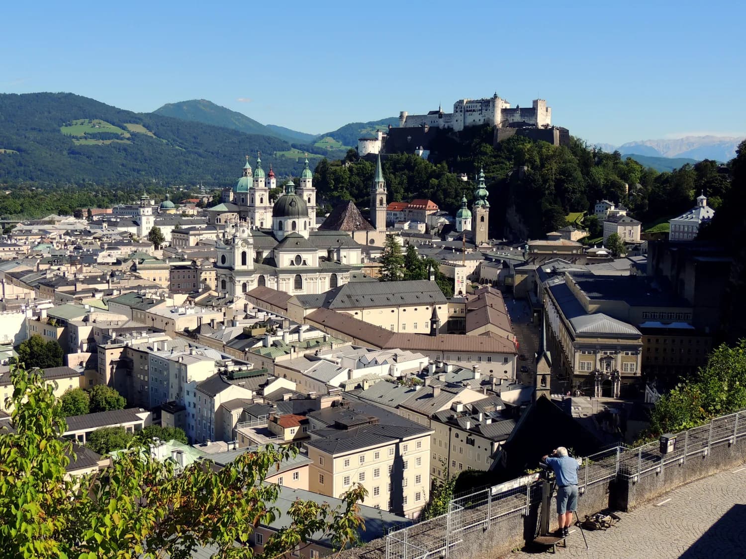Luftaufnahme von Salzburg mit Hohensalzburg-Festung, Domkuppel und Altstadtdächern vor Alpenhügeln