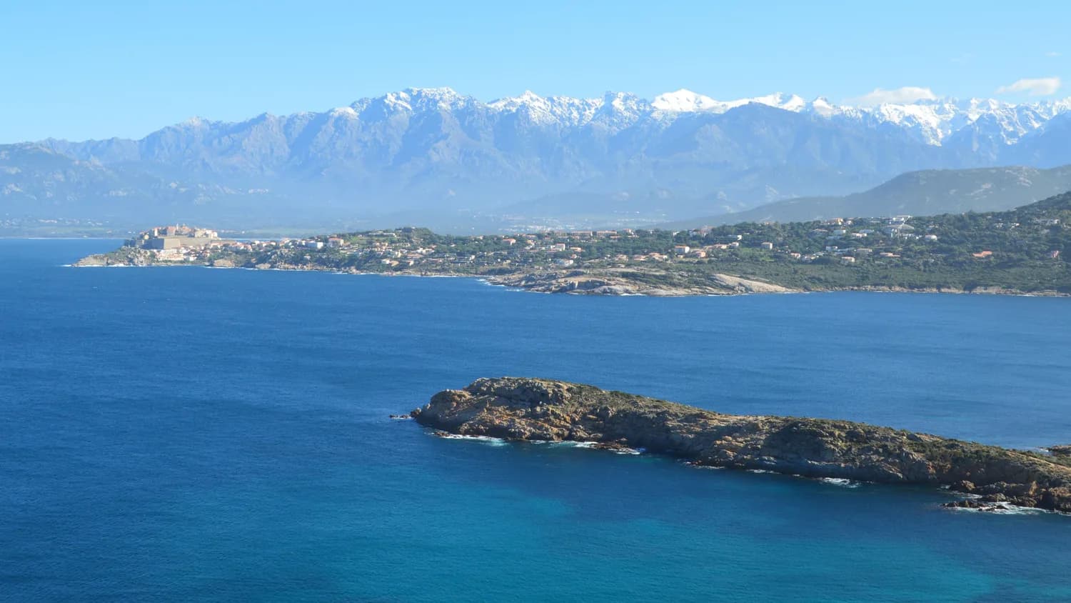 Küstenlandschaft bei Calvi auf Korsika mit Meer und Bergen im Hintergrund