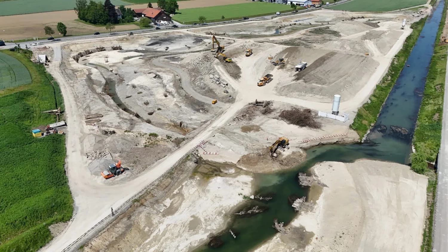 Luftaufnahme Renaturierungsprojekt Glatt beim Flughafen Zürich mit Baggern, Lastwagen, neuem Flussbett und angelegten Uferzonen