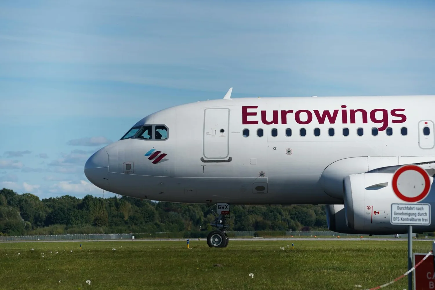 Eurowings Passagierflugzeug am Boden, seitliche Nahaufnahme des Cockpits und Rumpfs beim Rollen auf dem Rollfeld