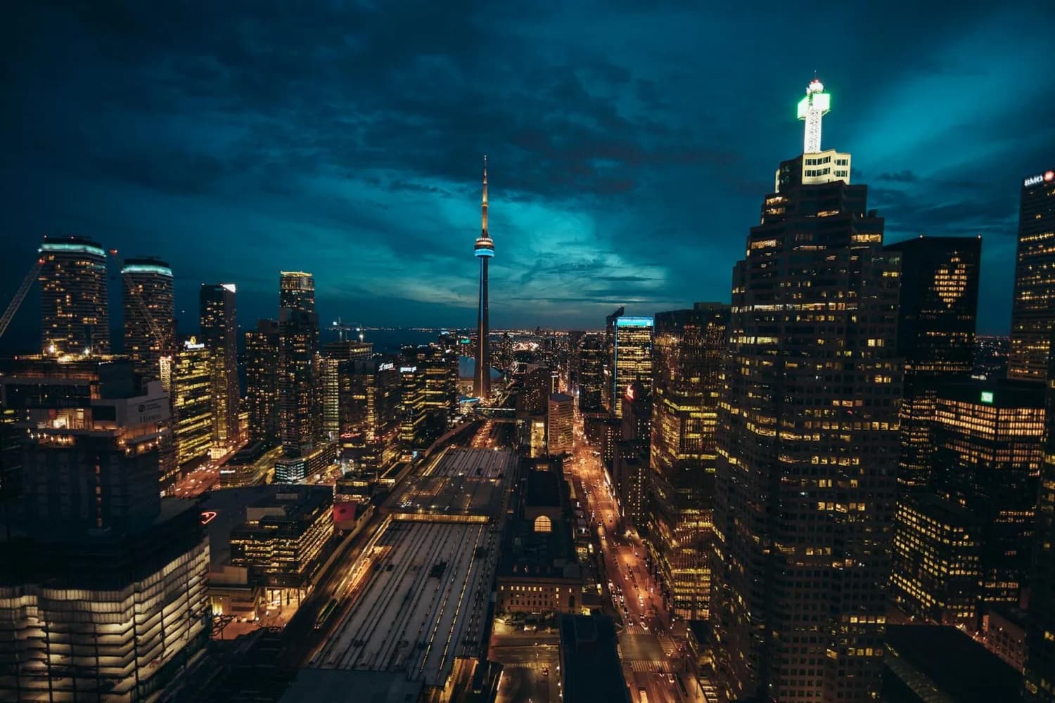 Toronto Skyline bei Nacht mit beleuchtetem CN Tower, Hochhäusern und belebten Straßen in Toronto, Kanada