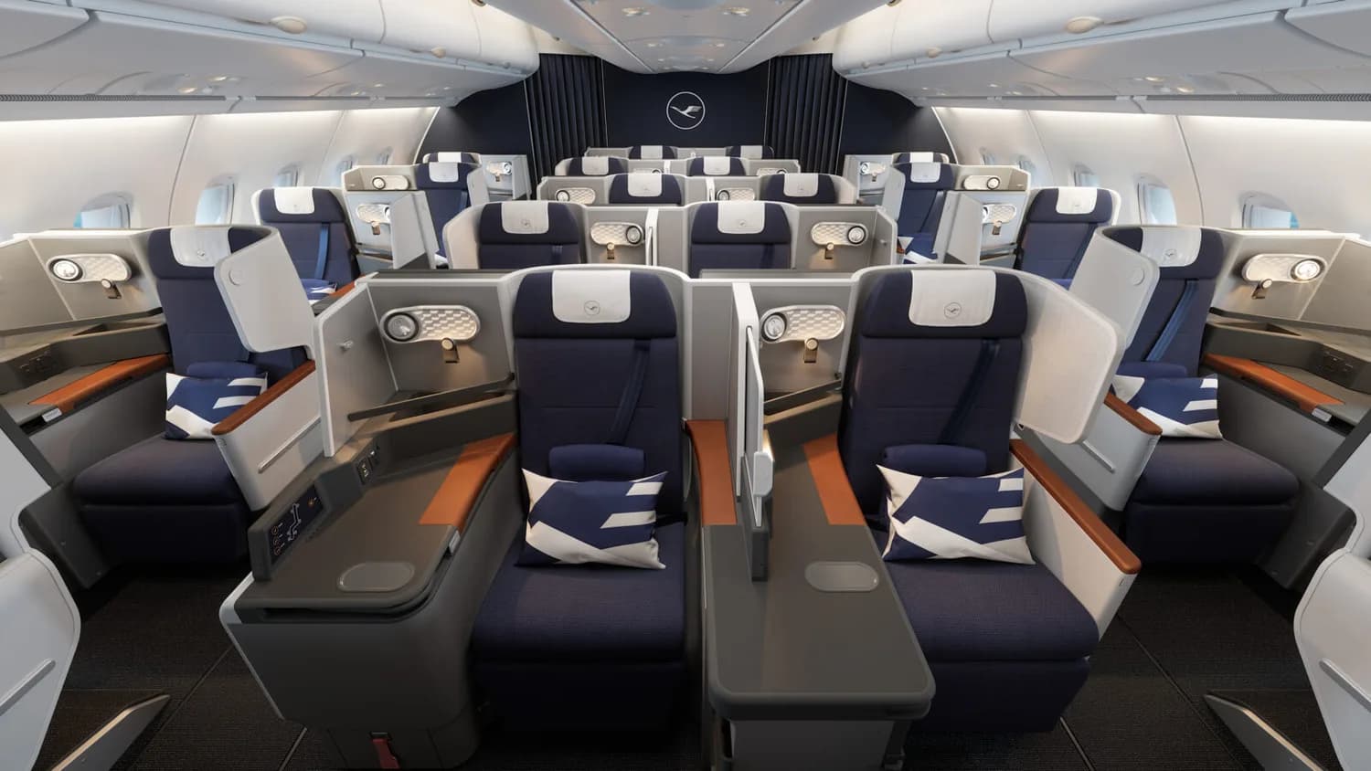 Lufthansa A380 Business Class Kabine mit Reihen vollflacher Sitze, privaten Liegesesseln, blauen Polstern und Kopfstützen, Trennwänden und dezent beleuchteten Ablagen