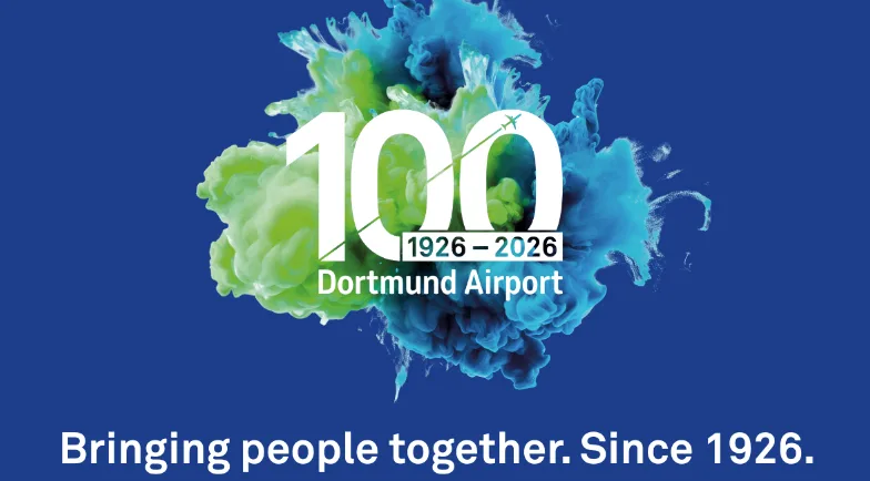 Logo zum hundertjährigen Jubiläum von Dortmund Airport mit großer Zahl 100, Jahresbereich 1926–2026 und Slogan auf blauem Hintergrund, farbiger grüner und blauer Rauchwolke als Designmotiv