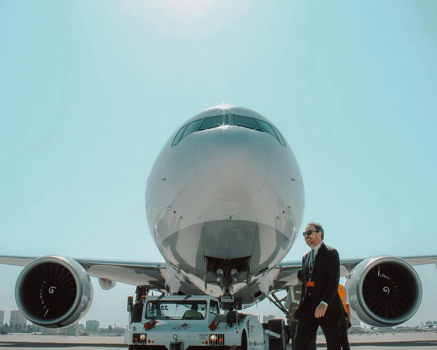 Frontansicht eines großen Passagierflugzeugs am Rollfeld mit Crewmitgliedern und Bodenfahrzeug, Thema Lufthansa Tarifvertrag und Luftfahrtpersonal
