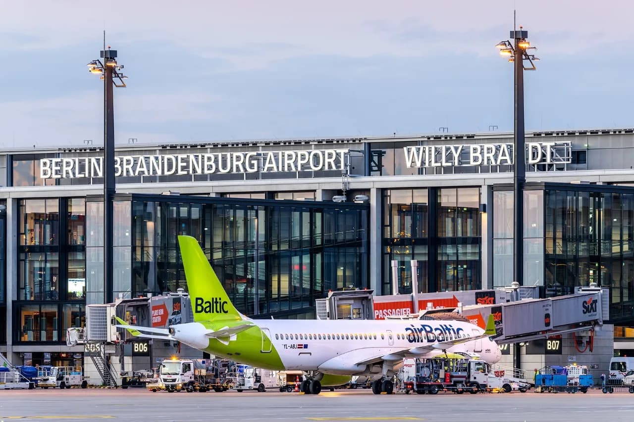 airBaltic Passagierflugzeug am Gate vor dem Terminal Berlin Brandenburg Willy Brandt, Bodenabfertigung in Kuusamo-Verbindung