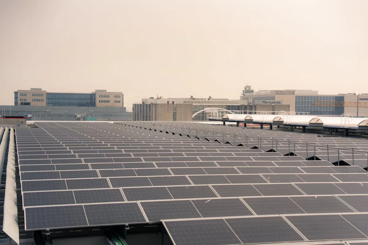 Dachmontage mit zahlreichen Solarpanels in Reihen vor städtischen Hotel- und Bürogebäuden (Sheraton)