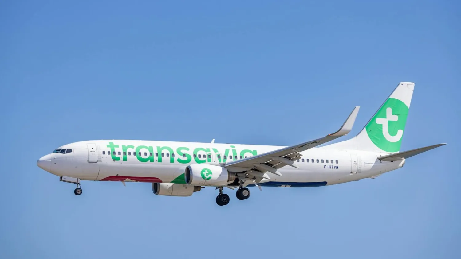 Transavia Passagierflugzeug Boeing im Landeanflug mit ausgefahrenem Fahrwerk vor blauem Himmel