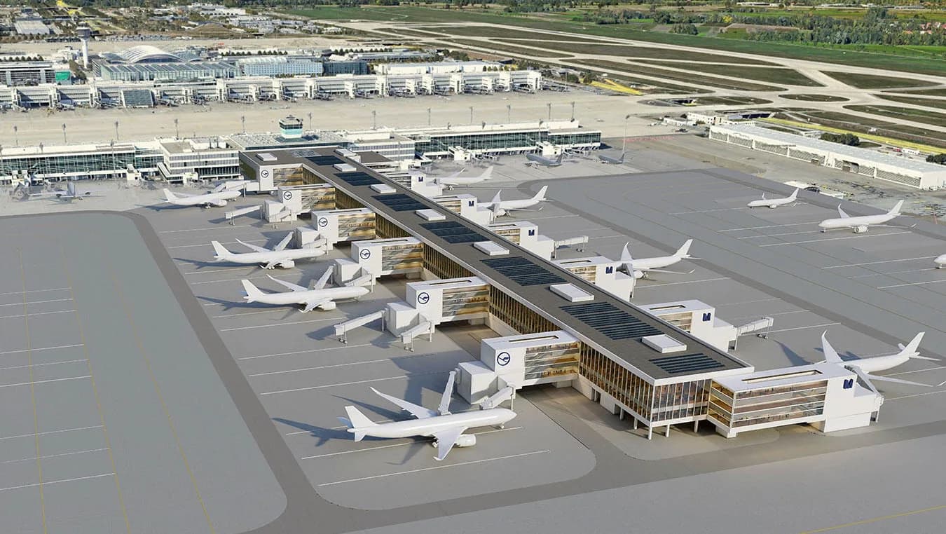Luftaufnahme des Münchner Flughafens mit neuem Terminalpier, mehreren an Gates geparkten Lufthansa-Flugzeugen und Flugbetriebsflächen.