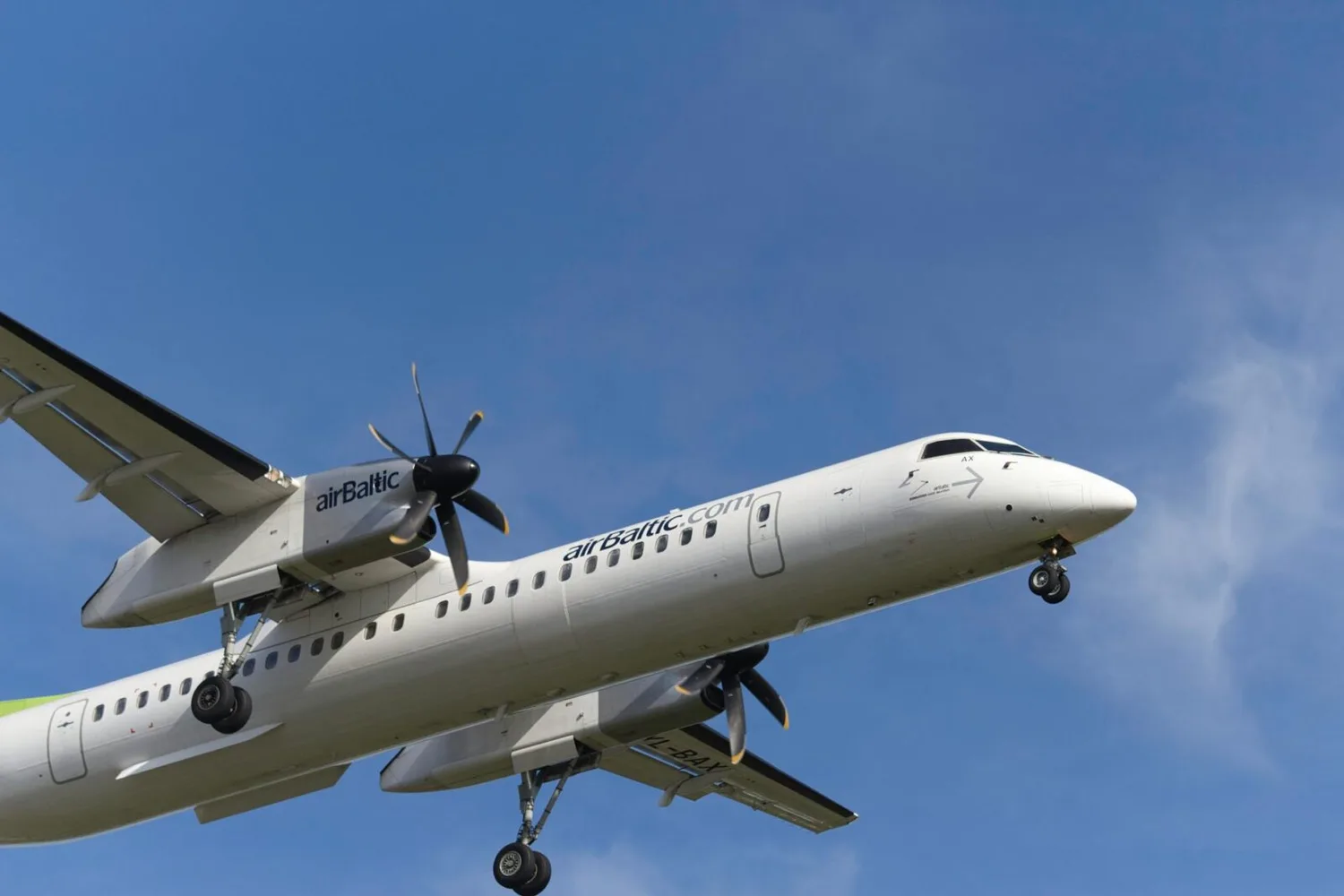 airBaltic Turboprop-Flugzeug im Landeanflug mit ausgefahrenem Fahrwerk, Airline-Branding sichtbar, Verbindung München nach Tallinn Riga Vilnius