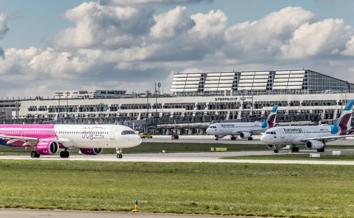 Flughafenterminal Stuttgart mit wartenden Passagierflugzeugen auf Rollbahn, Wizz Air in Pink und Eurowings Flottenmaschinen im Sommerflugplan am Flughafen Stuttgart