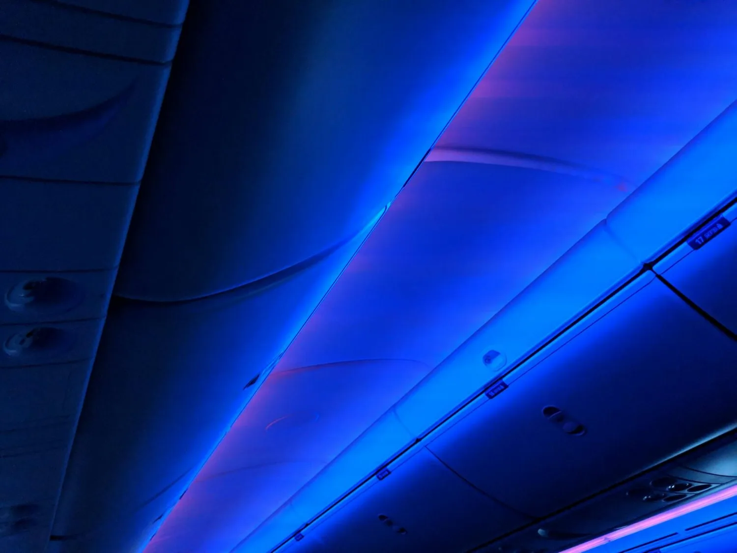 Kabineninnenraum eines Flugzeugs mit blau-violetter Ambientebeleuchtung, Verkleidung und Gepäckfächern bei Pressekonferenz zum Schneechaos am Flughafen München