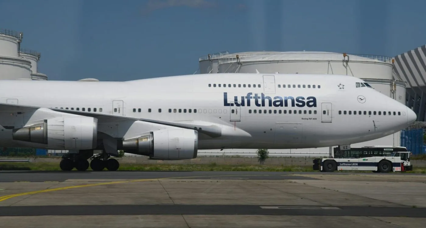 Lufthansa Boeing 747-400 am Flughafen auf dem Vorfeld, Seitenansicht des Rumpfs mit Triebwerken und Bodenfahrzeug