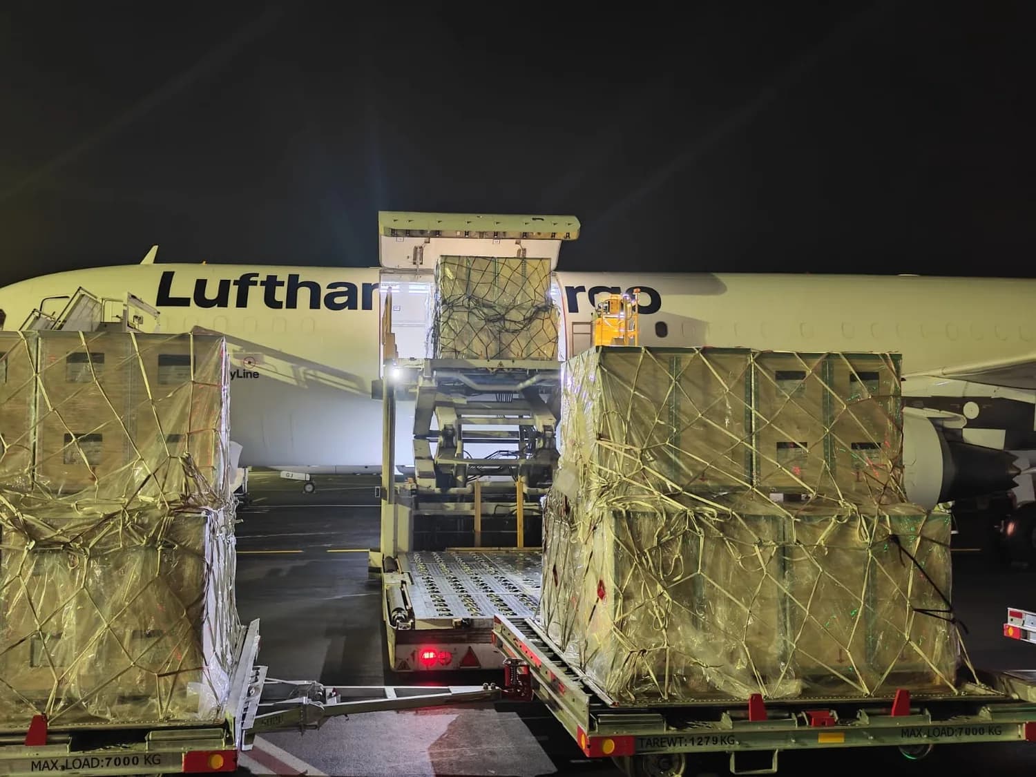 Lufthansa Cargo Frachter beim Nachtladungsbetrieb, Luftfrachtpaletten und verpackte Container werden per Gabel- und Ladeförderer in die Laderaumtür gehoben (Mercedes Charter CMN)