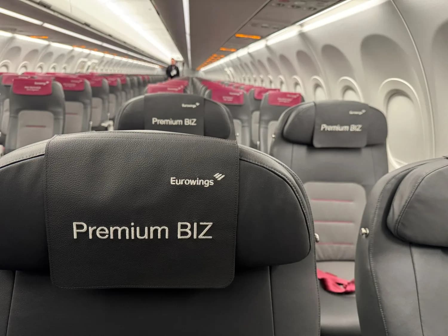 Eurowings Premium BIZ Sitzreihe im Flugzeugkabine am DUS Flughafen, schwarze Ledersitze mit Kopfstützen und rosafarbenen Details