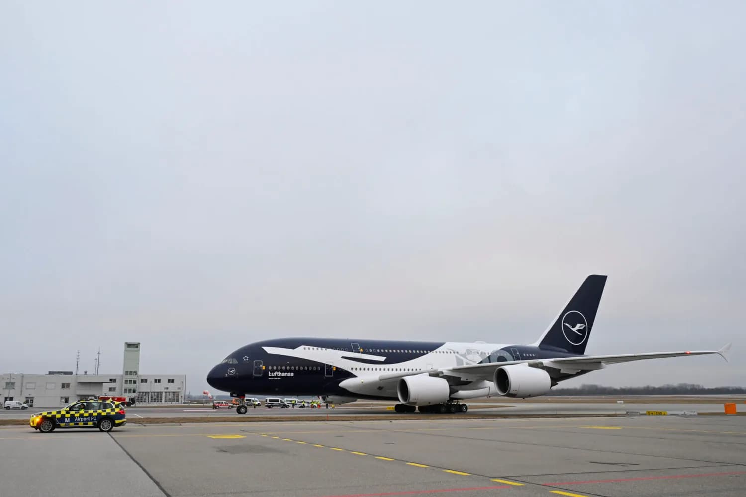 Lufthansa A380 in schwarzer Kranich-Livery Sonderlackierung auf Rollfeld mit Flughafenfahrzeug im Vordergrund