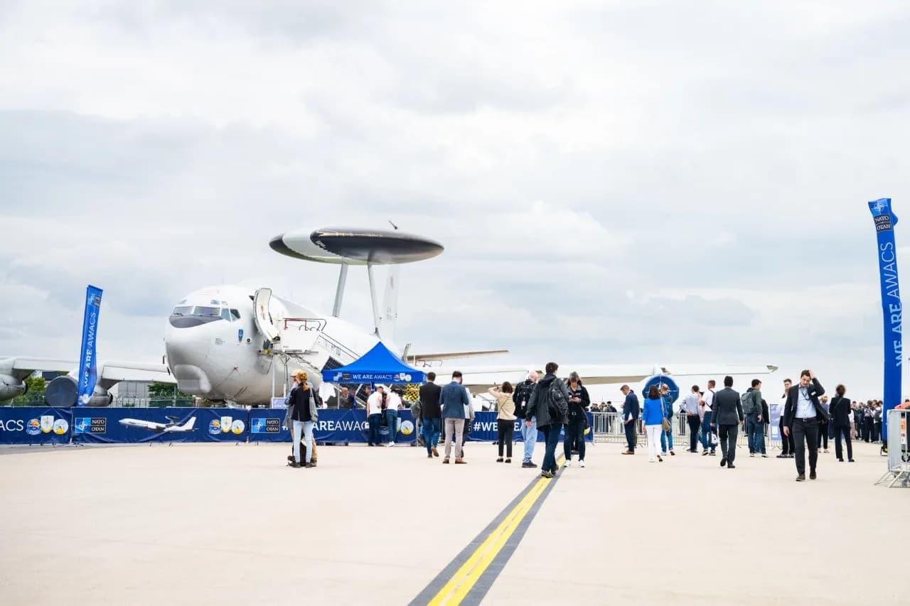Menschenmenge vor NATO AWACS-Aufklärungsflugzeug mit markanter Radarschüssel auf Flugfeld bei Veranstaltung