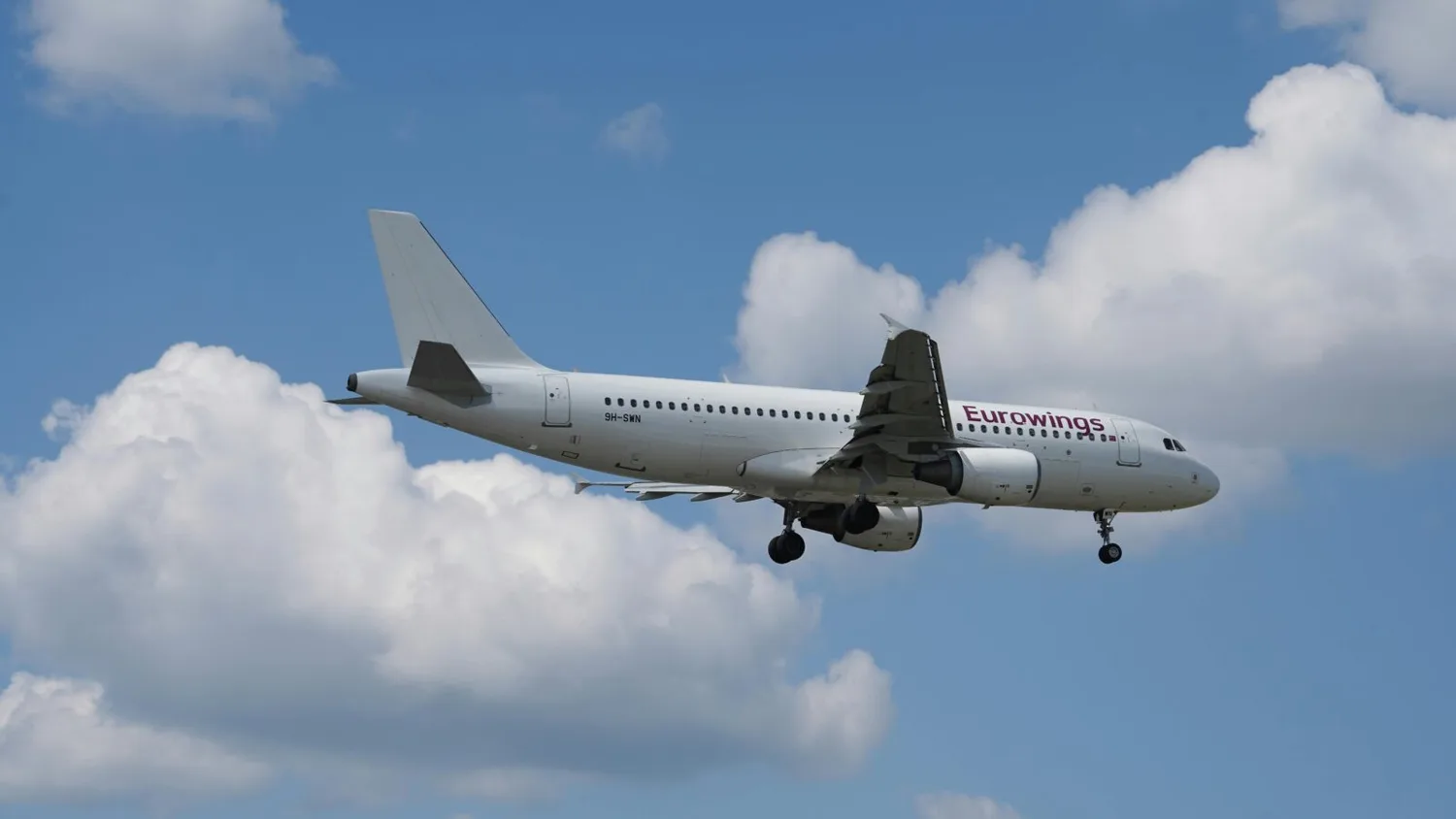 Eurowings Passagierflugzeug im Landeanflug vor blauem Himmel mit weißen Wolken