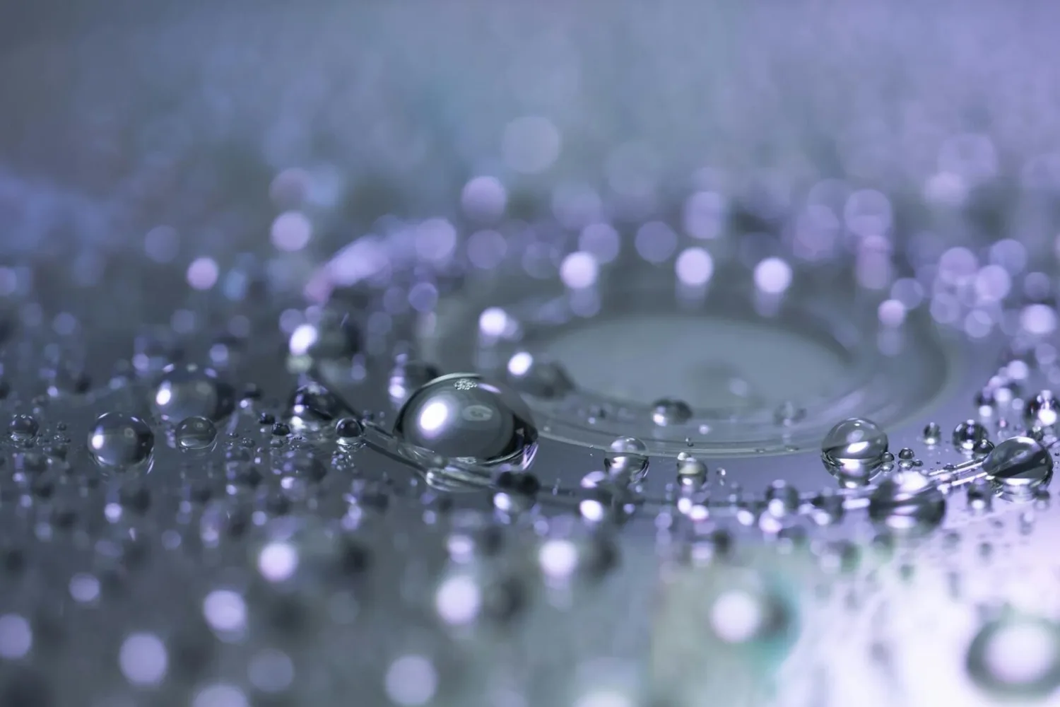Wassertropfen und Kondensationsperlen auf metallischer Oberfläche mit violettem Lichtschein, symbolische Darstellung von Wasserstofftechnologie für Flughafen Exeter