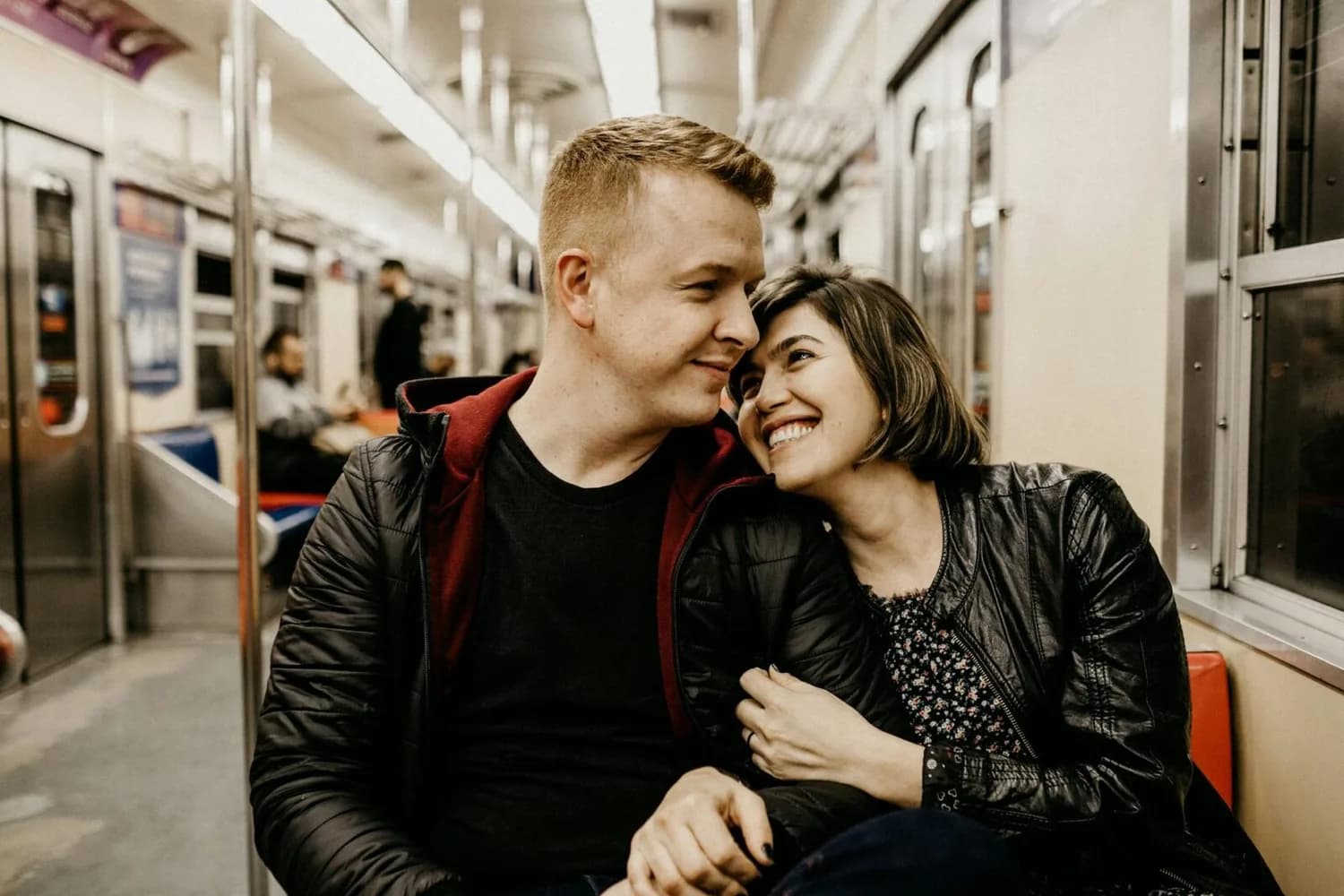Paar lächelnd und kuschelnd in U-Bahn während Städtereise in Europa