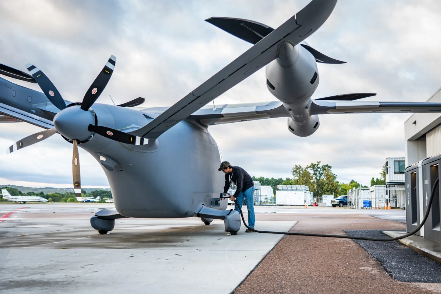 einer von drei A250-Testflugzeugen beim Aufladen am Boden, Nahaufnahme Propeller, Triebwerk und Techniker beim Betanken/Ladevorgang auf Rollfeld