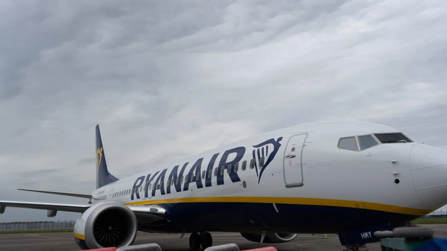 Ryanair Passagierflugzeug am Gate mit sichtbarem Logo und Seitenansicht bei bewölktem Himmel