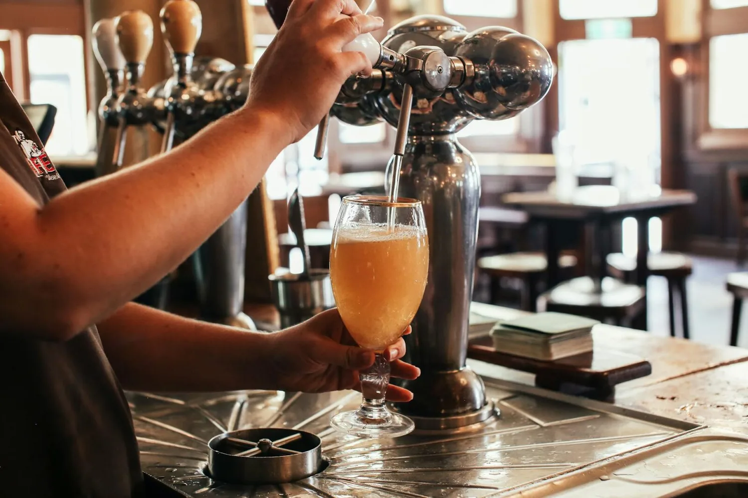 Bier vom Zapfhahn in Glas in Flughafenbar München, Airbeau Bier, Frühlingsszene im Schankbereich
