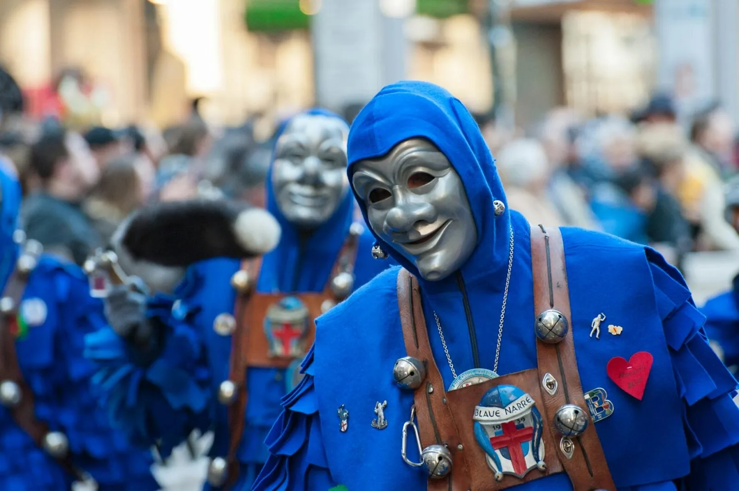 Närrische Fastnachtsfiguren in blauen Gewändern und silbernen Masken beim Umzug in Nürnberg, Trommeln und Verzierungen sichtbar