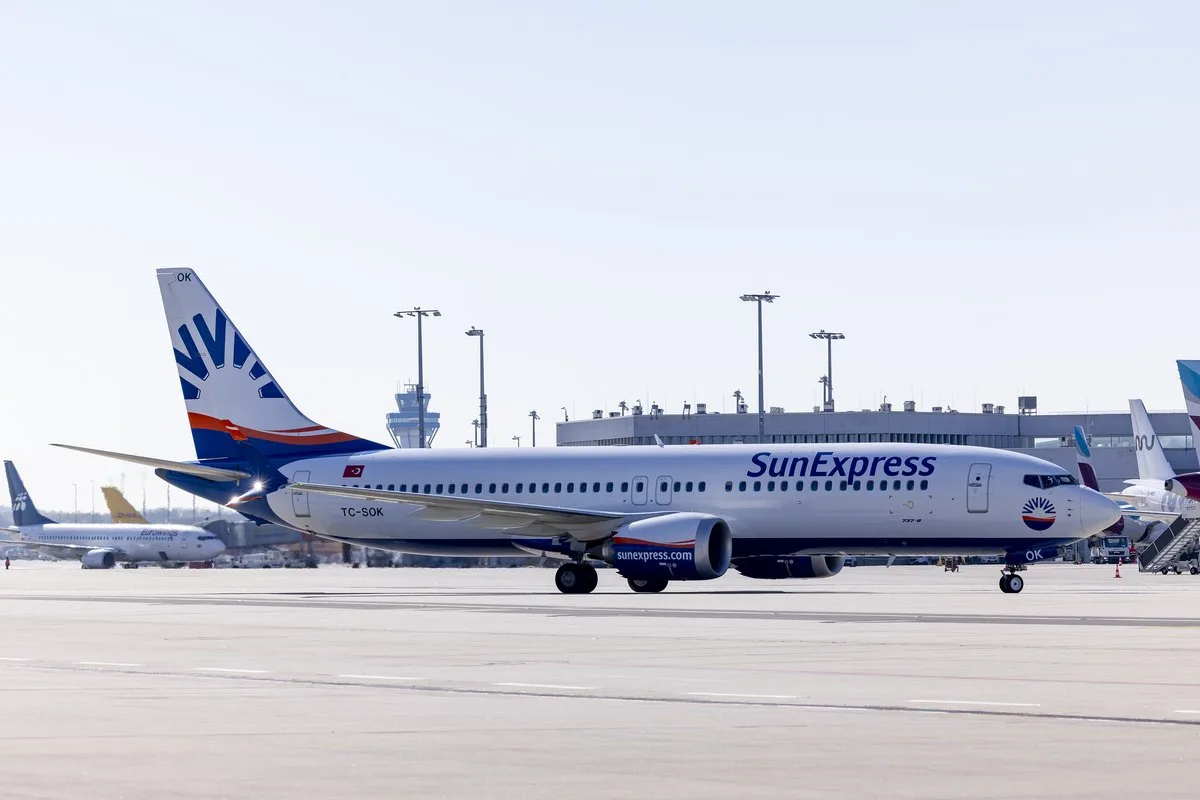 SunExpress Passagierflugzeug auf dem Vorfeld eines Flughafens mit Terminal im Hintergrund