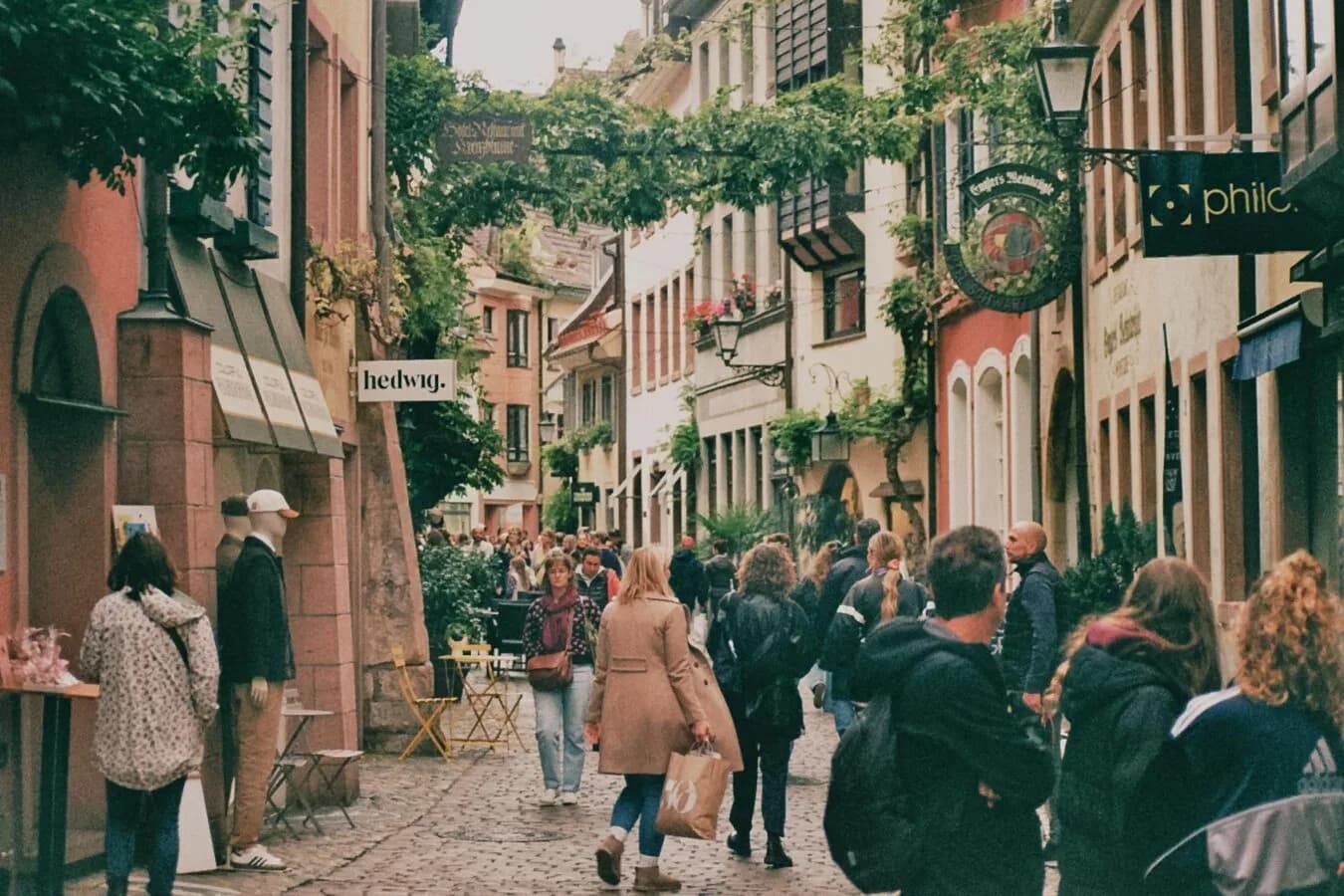 Belebte Fußgängerzone in Salzburg Innenstadt mit Kopfsteinpflaster, historischen Häusern, Schaufenstern und Spaziergängern