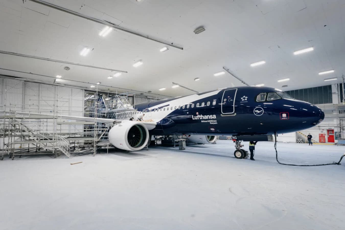 Lufthansa Airbus A320neo in spezieller Lackierung in einer Hallenwerkstatt mit Gerüsten und Wartungspersonal