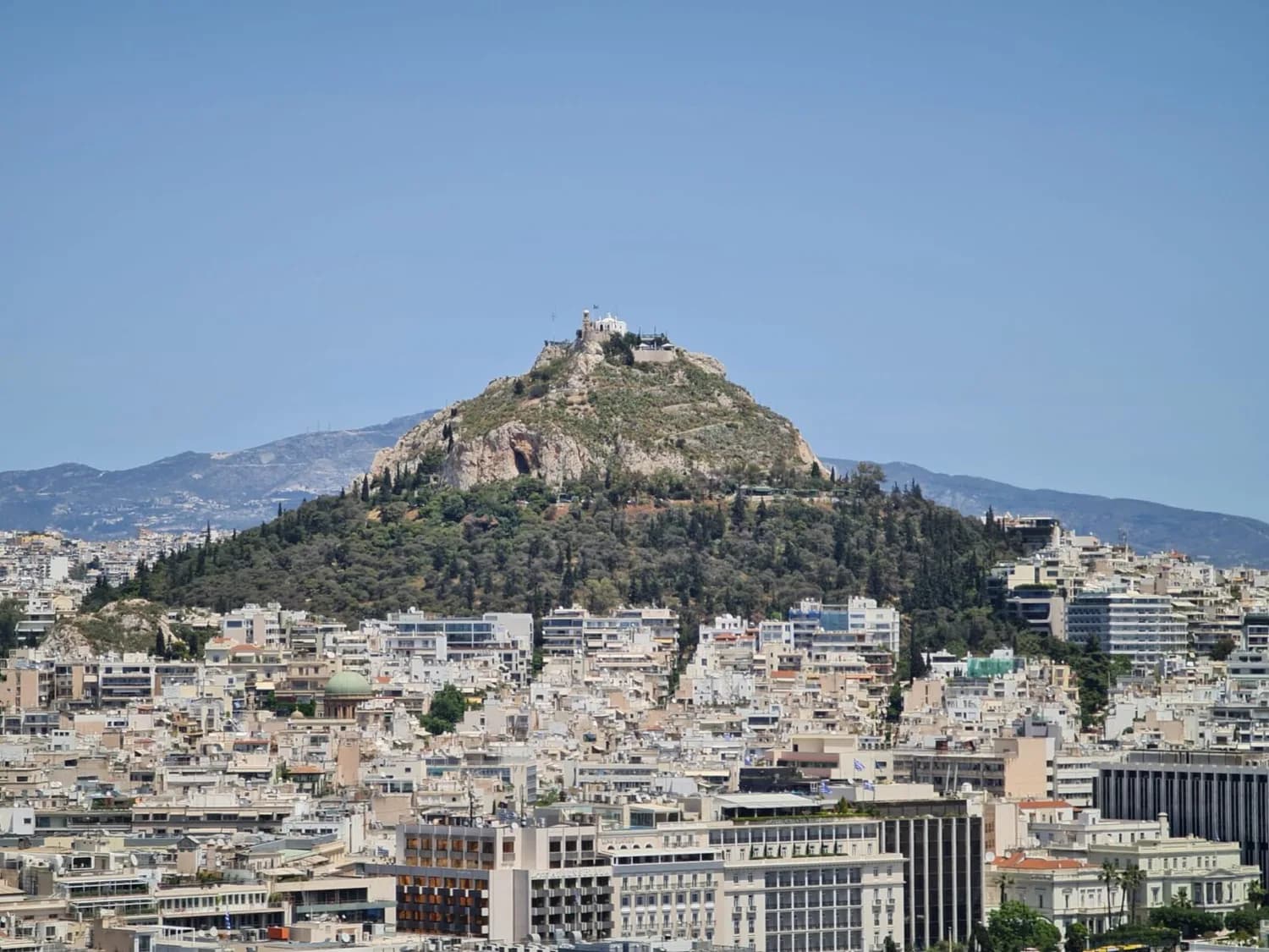 Lykavittos-Hügel mit Kapelle über dem dicht bebauten Stadtgebiet von Athen, Griechenland