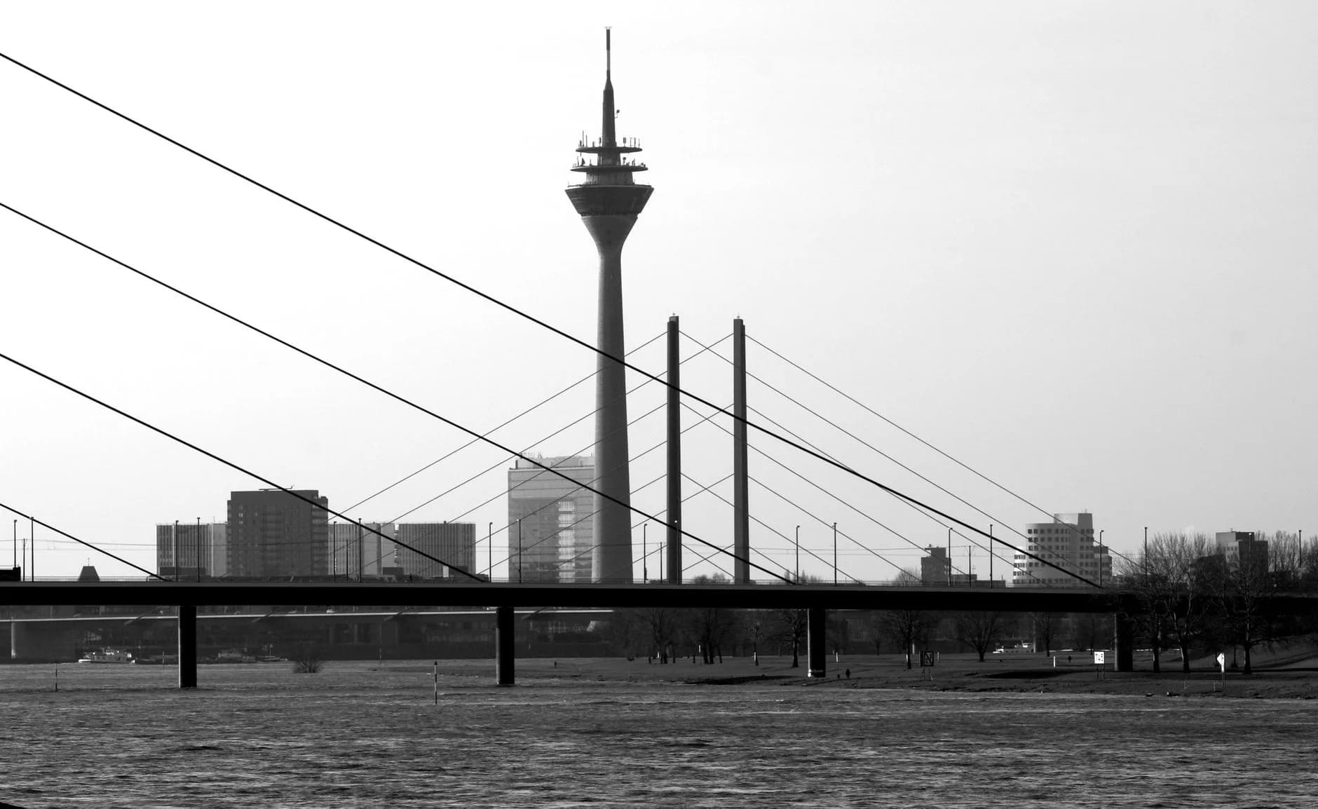 Schwarz-weiß Skyline von Düsseldorf mit Fernsehturm und Rheinkniebrücke über dem Fluss