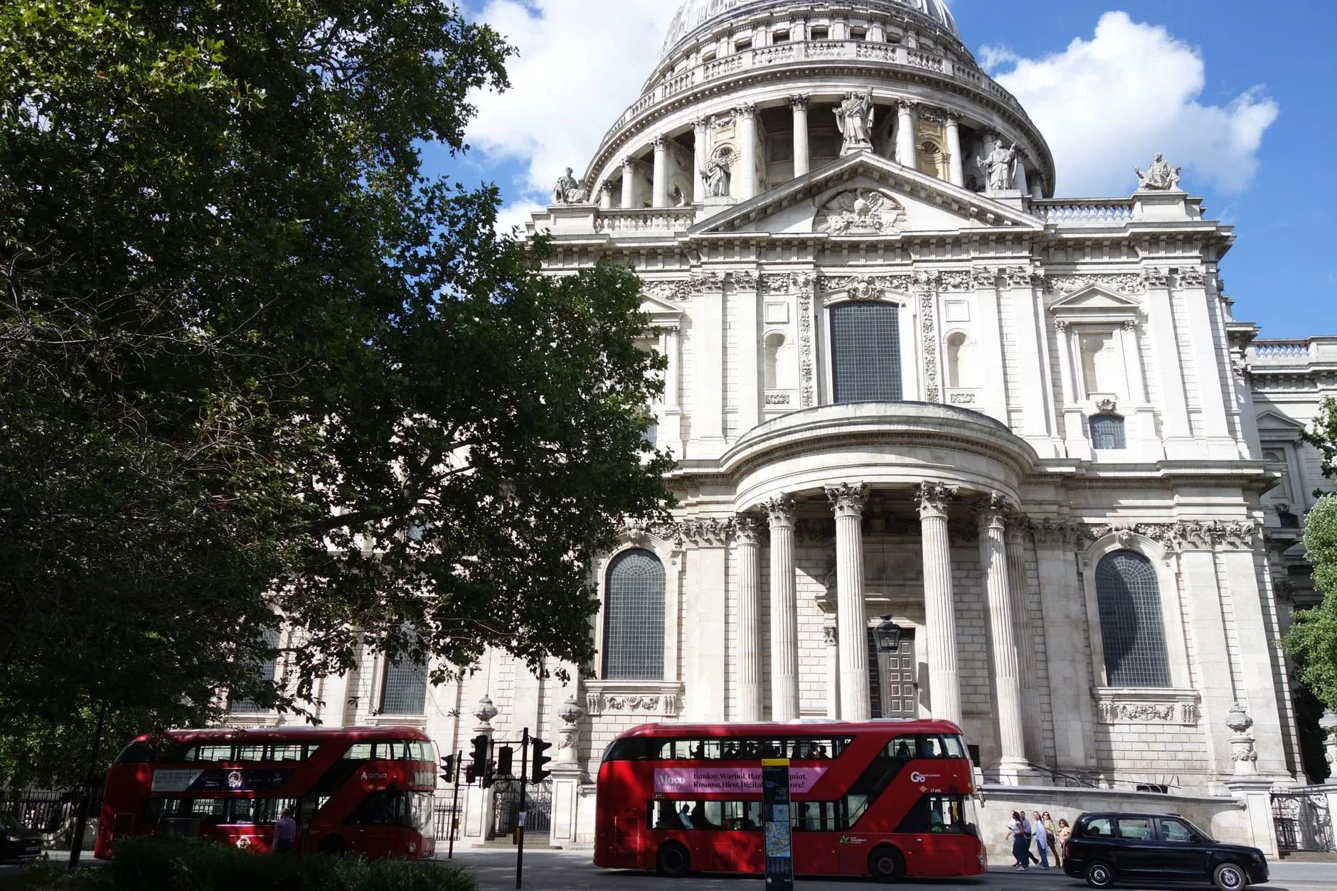 St. Paul's Cathedral in London mit roten Doppeldeckerbussen und schwarzem Taxi davor